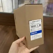 Omron 3G3MX2-AB002-V2 — lower terminal cover flipped open to show the input terminal block (L1, L2/N) on the left and the motor terminal block (T1, T2, T3) on the right, plus the bottom control terminal row