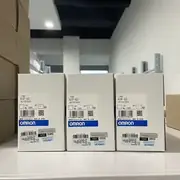 Omron 61F-G3 AC100-220V — three units standing side by side on a shelf with the model label on the front