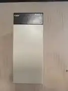 Omron C200HW-PA204 power supply -- installed in a working C200H panel with C200H CPU module to the right, the 5 VDC rail healthy for the I/O units.