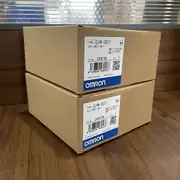 Omron CJ1W-ID211 16-point DC input module — installed on a CJ1M-CPU13 CPU rack between the CPU and a CJ1W-OD211 output module, with field wiring from proximity sensors and limit switches visible