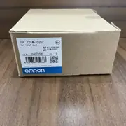 Omron CJ1W-ID262 — angled view of the same brown Omron-branded carton showing the top face and the side panel with the CJ1W-ID262 type label, the Ver. 1.0 subtext, the KCC-REM-OMR-CJ1W-00015 KC mark, the lot number 230511M, and the blue-and-white OMRON band