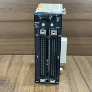Omron CJ1W-NC413 — front face of the slim CJ CPU-bus module on a wooden surface showing the blue NC413 label / MACH No. x10^1 and x10^0 rotary selector pair / X Y and Z U axis labels on the 7-segment display bank / RUN ERC ERH status LEDs / CN1 and CN2 40-pin headers with metal shield brackets on the upper edge / Y1X and U1Z axis pin labels at the base