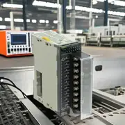 Omron CJ1W-OC211 16-point relay output unit — installed on a CJ2M-CPU14 CPU rack between two CJ1W-ID211 input modules, with field wiring from 16 × 24 VDC pneumatic valve solenoids with flyback diode suppression on the output side