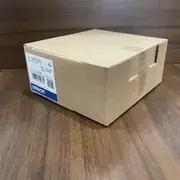 Hand holding the CJ1W-OD232 box to show the slim 31 mm-wide module carton size