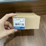 Hand holding the CJ1W-OD232 box to show the slim 31 mm-wide module carton size
