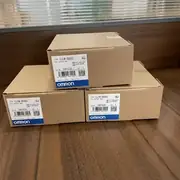 Omron CJ1W-OD262 CJ-series 64-point PNP-sourcing output unit in its cardboard shipping carton with the type label visible, three boxes stacked