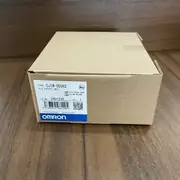 Single CJ1W-OD262 carton in close-up showing the front face of the box with TYPE / LOT No. / QTY 1 / barcode, the Omron Corporation logo at the bottom