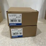 Omron CJ1W-PD022 — two brown cardboard boxes stacked vertically, each with the CJ1W-PD022 type label, KCC-REM-OMR-CJ1W-00029 cert, lot 230913M, and the OMRON Corporation wordmark with the blue/white band at the bottom