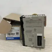 Omron CJ1W-PRM21 — nameplate view of the gray plastic side of the PRM21 module showing the OMRON wordmark / CJ1W-PRM21 PROFIBUS DP-V1 Master Unit label / PROFIBUS Number 0742 / Lot No. 240402N 0028 / Ver. 3.0 / Batch No. 500597367 / OMRON Corporation Kyoto, 600-8530 JAPAN / MADE IN THE NETHERLANDS / PROFIBUS trademark / cULus LISTED 95HB IND.CONT.EQ. / KCC-REM-OMR-CJ1W-00078 / CE / UKCA / EAC marks / brown Omron cardboard carton in the background