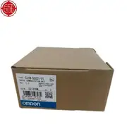 Omron CJ1W-SCU21-V1 — brown Omron-branded cardboard shipping carton with the CJ1W-SCU21-V1 type label, the SERIAL COMMUNICATION UNIT Ver. 1.3 subtext, the KCC-REM-OMR-CJ1W-00015 KC mark, the lot number 221209M, the barcode 4547648597272, the NO CONNECTOR note, and the blue-and-white OMRON band along the bottom