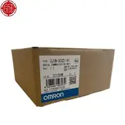 Omron CJ1W-SCU21-V1 — second angle of the brown Omron-branded shipping carton showing the top face with the CJ1W-SCU21-V1 type label, the lot number 221209M, the barcode 4547648597272, the KC mark, the NO CONNECTOR note, and the blue-and-white OMRON band