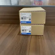 Omron CJ1W-SCU22 — brown Omron-branded cardboard shipping carton with the CJ1W-SCU22 type label, the Ver. 1.3 subtext, the KCC-REM-OMR-CJ1W-00015 KC mark, the lot number 230418M, the barcode, the blue-and-white OMRON band along the bottom, and the SERIAL COMMUNICATION UNIT subtext