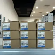 Omron CJ1W-SCU22 — angled view of the same brown Omron-branded carton showing the top flap, the CJ1W-SCU22 type label, the Ver. 1.3 subtext, the lot number 230418M, the KCC-REM-OMR-CJ1W-00015 KC mark, and the blue-and-white OMRON band along the bottom edge