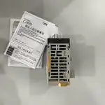 Omron CJ1W-SCU31-V1 — black module on a white surface next to a white Omron-branded quick-start sheet and a warranty card showing the SCU31-V1 model code and the CJ-series spec table