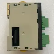 Omron CJ1W-SCU32 — bottom view of the SCU32 module showing the gray plastic lower housing, the gold contact fingers of the 40-pin backplane connector on the left, the two green 5-pin RS-422A/485 terminal blocks on the right edge, and the yellow release lever at the top