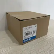 Omron CP1W-20EDR1 — the carton opened with the expansion unit visible inside the foam