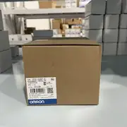 Omron CP2E-S30DT-D installed on a DIN rail beside an NB HMI linked via Ethernet, with one CP1W-8ED expansion module attached on the right side and the option slot filled with a CP1W-CIF01 serial board