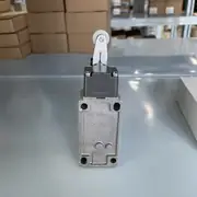 Omron D4B-4111N aluminum safety limit switch — front view showing the die-cast aluminum housing (40 × 99 mm) with the resin roller lever in the vertical free position, the operation indicator (orange), and the rubber gasket for IP67 sealing