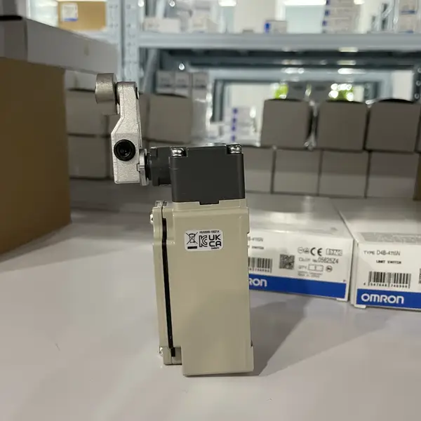 Omron D4B-4115N safety limit switch in front view, showing the die-cast aluminum body, the stainless steel roller lever actuator, the M20 conduit entry on the side, and the snap-action 1NC/1NO contact screw terminals under the cover
