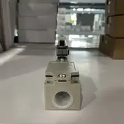 Omron D4B-4116N limit switch — side profile showing the rugged metal housing, the head-mounted roller lever rotated to the side, and the M20 cable gland on the bottom