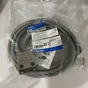 Omron D4C-1201 limit switch — sealed plastic bag with the metallic limit switch body, coiled 3 m cable, Japanese instruction sheet, and Omron label