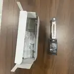 Omron D4N-112G safety limit switch — installed as a safety door interlock on a robotic cell enclosure with the roller lever depressed by the door cam when closed; the Pg13.5 cable gland visible at the bottom with the NC contact wired to a G9SE-201 safety relay