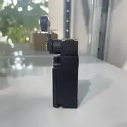 Omron D4NA-4122 — side view showing the plastic housing, the M20 conduit entry on the bottom face, and the panel-mounting holes