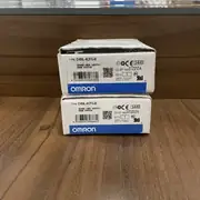 Omron D4NL-4CFG-B — front face of the guard-lock safety-door switch showing the plastic body, the top operation-key entry slot, the orange LED operation indicator window, and the M20 conduit boss on the bottom