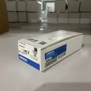 Omron D4NS-1AF safety door interlock switch — head close-up showing the key insertion slot with a D4DS-K2 vertical operation key inserted (the white plastic key visible protruding from the head)