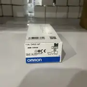 Omron D4NS-1AF safety door interlock switch — installed on a machine guard frame with the D4DS-K2 operation key on the hinged door in the closed position; the Pg13.5 cable gland carries 4 wires (NC + NO + 24 VDC + PE) to a G9SB-200-B safety relay