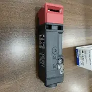 Omron D4SL-N4EFA-DN compact solenoid-locking safety-door switch in front view, showing the plastic head with the operation-key slot at the top, the orange operation LED window, and the M20 conduit entry on the bottom