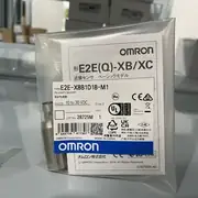Omron E2E-X8B1D18-M1 — front view of the M18 shielded inductive sensor showing the PBT active face, the brass / stainless barrel, and the two lock nuts on the threaded body