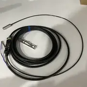 Omron E2EC-C1R5D1 — sensing head detail showing the small ABS sensing surface flush with the brass case rim and the shielded inductive coil behind it
