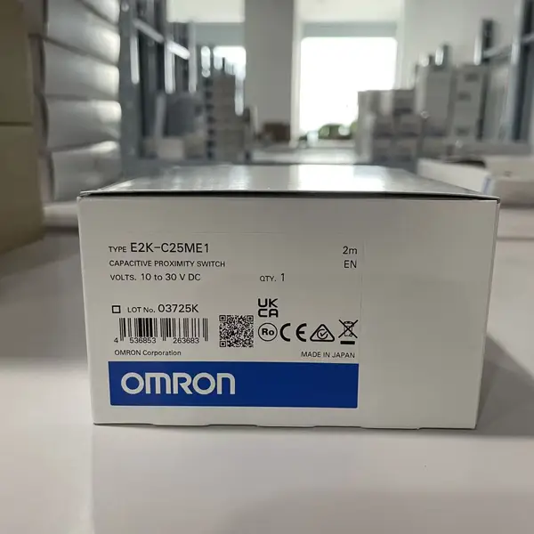 Omron E2K-C25ME1 2M — front view of the M30 cylindrical capacitive sensor head with the red operation LED on the cap and the 2 m pre-wired oil-resistant cable exiting the rear
