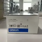 Omron E2K-C25ME1 2M — front view of the M30 cylindrical capacitive sensor head with the red operation LED on the cap and the 2 m pre-wired oil-resistant cable exiting the rear