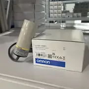 Omron E2K-C25ME1 2M — rear face showing the brown / blue / black 3-wire output cable and the sensitivity adjustment through-hole