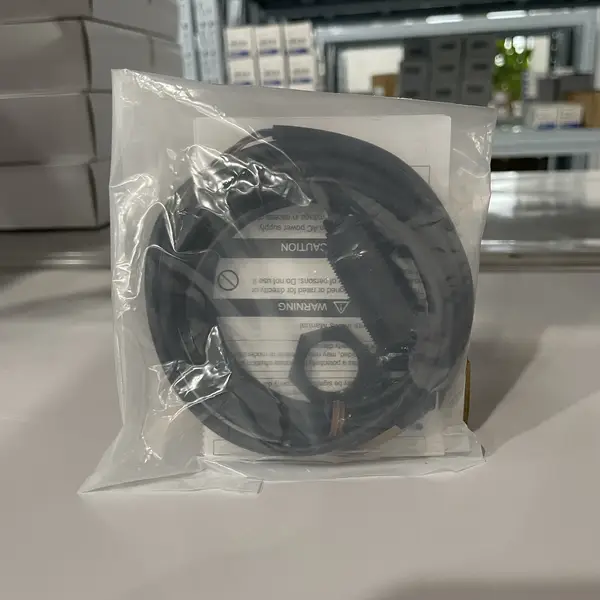 E3FA-BP12 2M sensors in sealed Omron-branded bags, with the M18 ABS body and 2 m cable visible through the packaging