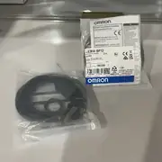 E3FA-BP12 2M with the instruction manual and the 2 m oil-resistant PVC cable, showing the compact M18 cylindrical body