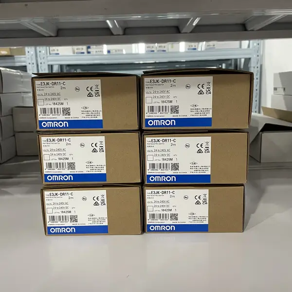 Omron E3JK-DR11-C — front face of the M18 plastic diffuse-reflective sensor showing the red 624 nm LED emitting window, the orange operation indicator LED, and the lockable front body section