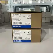 Omron E3JK-DR11-C — pre-wired end showing the 2 m VCTF cable with brown, blue, black, white, and yellow conductors entering the sensor through the strain-relief gland