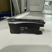 Omron E3NX-CA6 — black E3NX-CA6 fiber amplifier with a clear top cover, side label reading E3NX-CA6 / Brown: 10 to 30VDC / Blue: 0V / Black: OUT / MADE IN JAPAN, and the gold wire-saving connector pins on the rear face on a white surface
