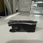 Omron E3NX-CA6 — rear view of the black E3NX-CA6 fiber amplifier showing the gold wire-saving connector pins on the rear face, the CE mark, the WEEE bin symbol, and the OMRON Corporation Kyoto 600-8530 JAPAN text on a white surface