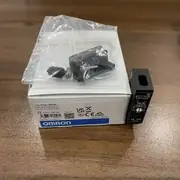 Omron E3S-AR36 — side profile showing the slim housing, the E39-L70 mounting bracket pre-fitted, and the M12 connector exit