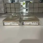 Omron E3S-DBN21 + E39-R8 reflector mounted at opposite sides of a PET bottling line conveyor, detecting clear PET bottles passing through the beam — IP69K Ecolab-certified for direct washdown mounting