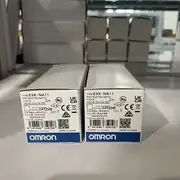 Omron E3X-NA11 2M NPN fiber amplifier - front view showing the 10x31.5x64.3 mm slim housing, the 4-turn potentiometer sensitivity adjustment with mechanical clutch, the 5-level LED bar display (4 green + 1 red excess-gain indicator), and the operation LED