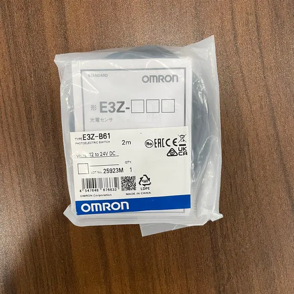 Omron E3Z-B61 2M — front view of the compact ABS housing showing the red LED emitter window, the receiver lens, and the four-wire pre-wired cable coming out of the rear