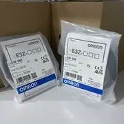Omron E3Z-D82 diffuse-reflective photoelectric sensor — top view showing the yellow operation indicator window on the top of the housing and the sensitivity adjustment trimmer on the rear face