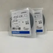 Omron E3Z-LS61 — two anti-static sealed bags standing upright, each with the E3Z-LS61 type label, OMRON blue-and-white band, lot 12424M, and RoHS / UKCA / CE marks