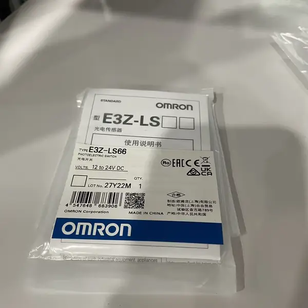 Omron E3Z-LS66 — front face of the E3Z rectangular housing showing the red 680 nm LED emitter window, the receiver lens, and the orange operation LED indicator on the top of the case