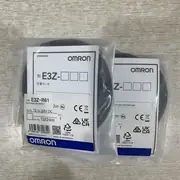 Omron E3Z-R61 2M 4 m retro-reflective photoelectric sensor — front view showing the 20 × 11 × 31 mm cuboid housing with the red LED beam emitter and polarization-filtered receiver window on the front face, the orange operation LED, and the green stability LED on the rear
